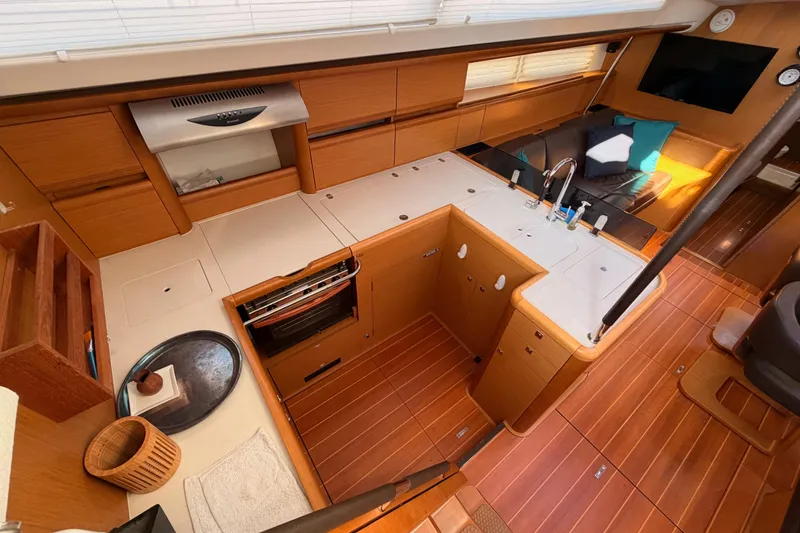 Slide: The Image of Luxurious interior of a 2013 Jeanneau 57 yacht featuring a modern kitchen and seating area. - 27