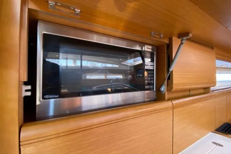 Slide: The Image of Microwave in 2013 Jeanneau 57 yacht kitchen, featuring sleek wooden cabinetry. - 32