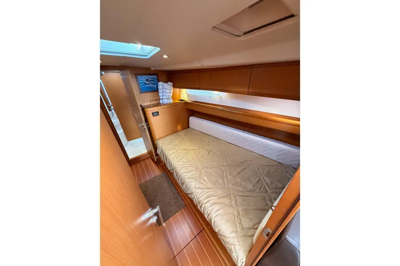 Slide: The Image of Cozy cabin interior of 2013 Jeanneau 57 yacht with wooden finishes and comfortable bedding. - 39