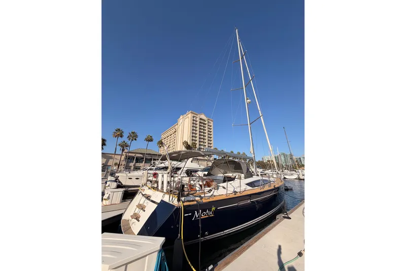 Slide: The Image of 2013 Jeanneau 57 yacht docked at marina with clear blue sky. - 4