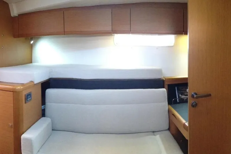 Slide: The Image of 2013 Jeanneau 57 yacht interior cabin with wooden cabinetry and cozy seating. - 45