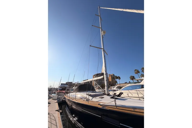 Slide: The Image of 2013 Jeanneau 57 yacht docked under clear blue sky. - 7