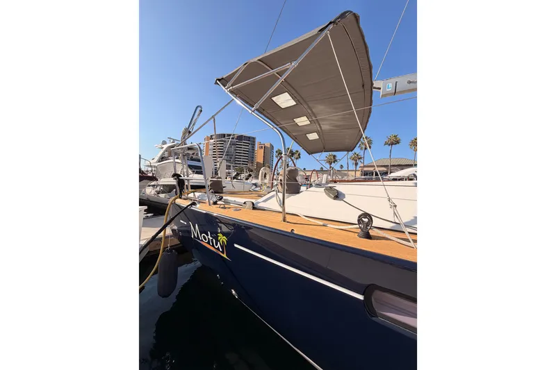 Slide: The Image of 2013 Jeanneau 57 sailboat docked, featuring a sunshade and sleek design. - 9