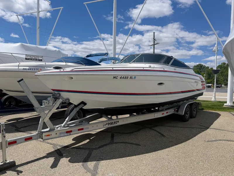 Slide: The Image of A white motorboat on a trailer, surrounded by other boats outdoors. - 2