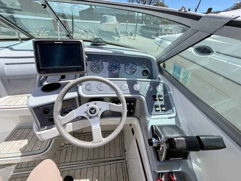 Slide: The Image of The cockpit of a boat with a steering wheel, gauges, and a screen. - 4
