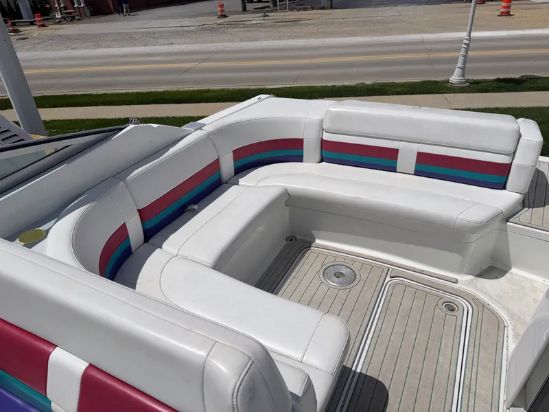 Slide: The Image of A boat with white seats and colorful stripes is on land. - 5