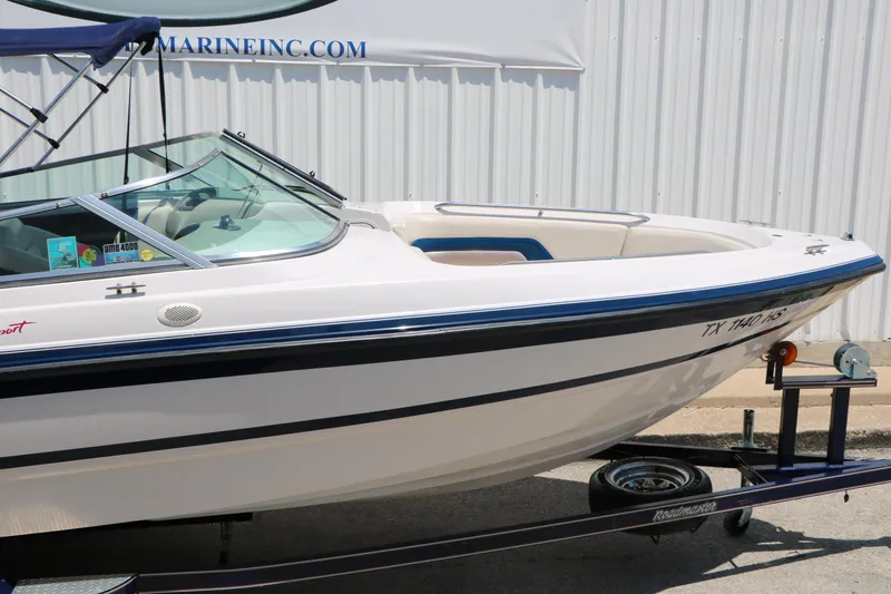 Slide: The Image of 1996 Chaparral 2330 SS boat on trailer, white with blue accents, parked outdoors. - 13