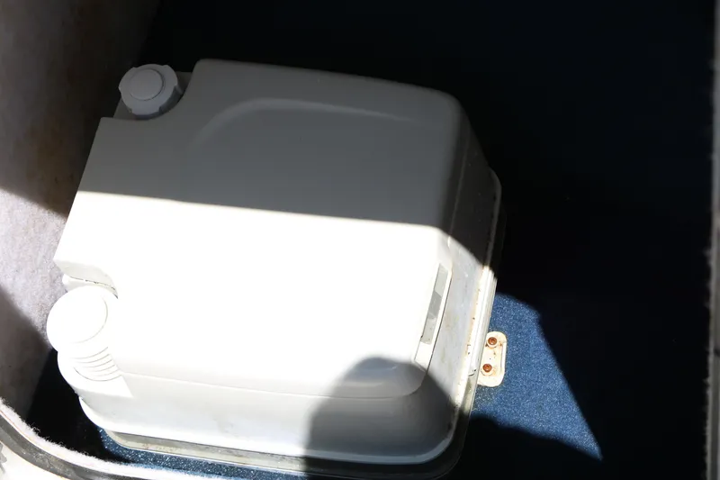 Slide: The Image of Storage compartment in a 1996 Chaparral 2330 SS boat, featuring a white container. - 27