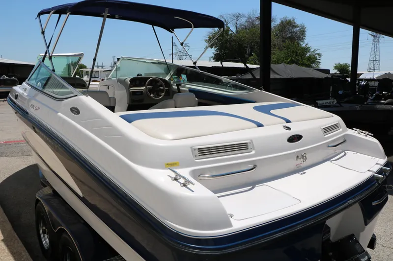 Slide: The Image of 1996 Chaparral 2330 SS boat with blue and white design, parked on a trailer. - 9