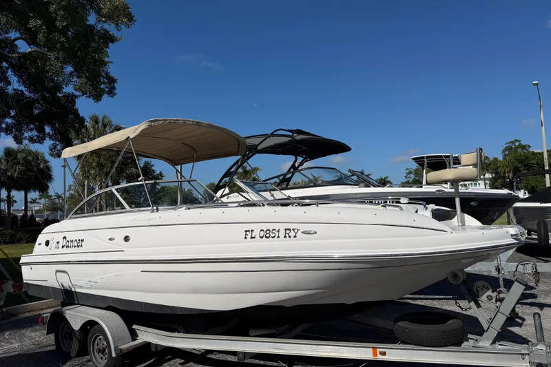 The Image of 2005 Starcraft Aurora 2210 OB boat on trailer, sunny day, palm trees in background. - 0