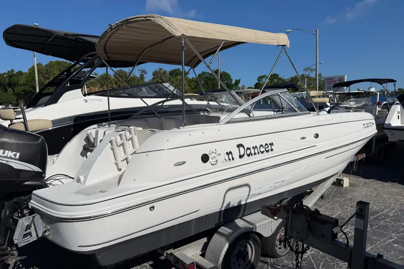 Slide: The Image of 2005 Starcraft Aurora 2210 OB boat with canopy, parked on a trailer in a marina. - 4