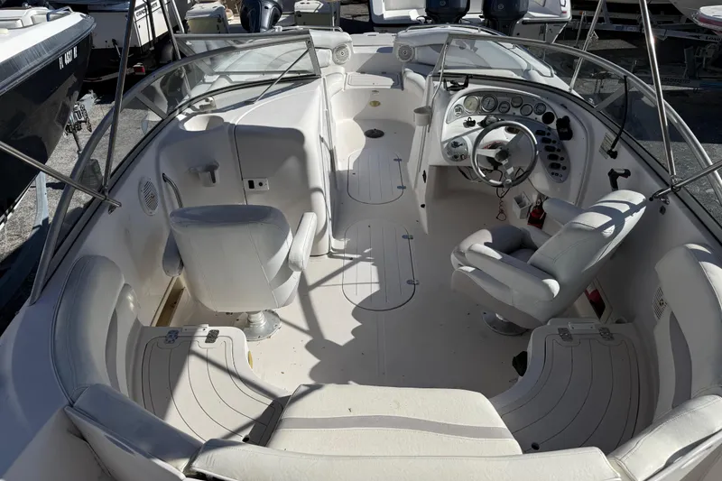 Slide: The Image of 2005 Starcraft Aurora 2210 OB boat interior with white seating and steering console. - 8