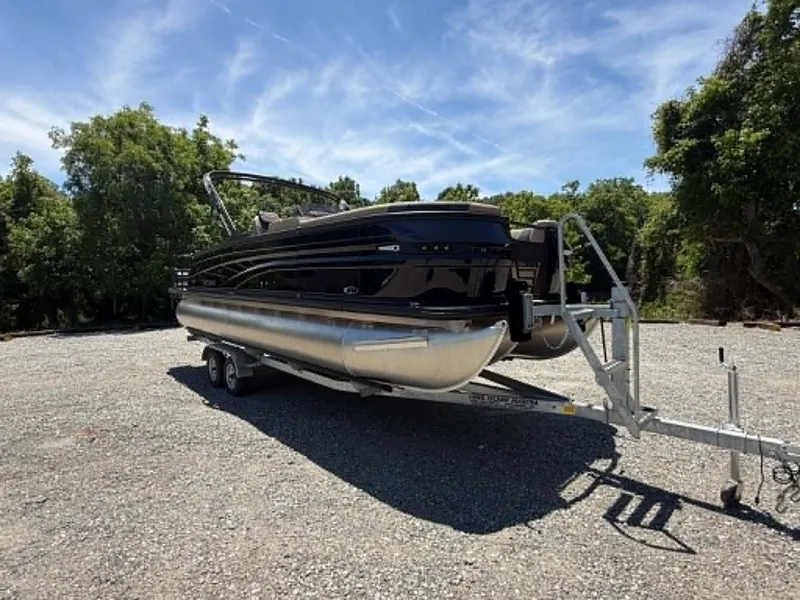 The Image of 2026 Sylvan L-3 DLZ Platnium pontoon boat on trailer outdoors. - 1