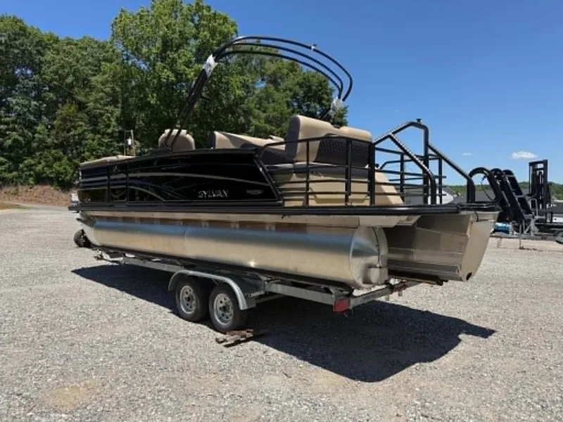 Slide: The Image of 2026 Sylvan L-3 DLZ Platinum pontoon boat on trailer outdoors. - 18