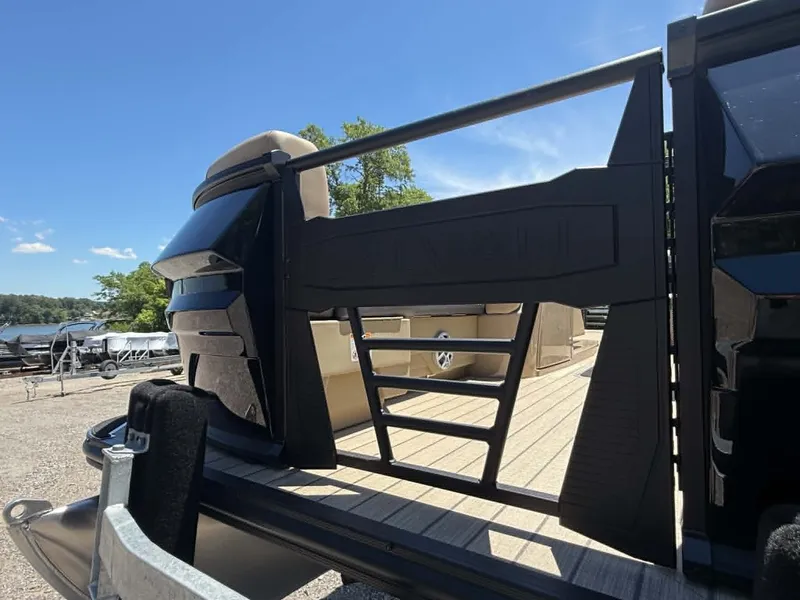 Slide: The Image of 2026 Sylvan L-3 DLZ Platnium pontoon boat parked by the shore. - 21