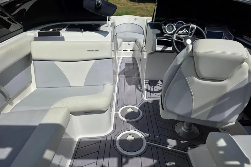 Slide: The Image of 2019 MasterCraft XT23 boat interior with sleek seating and modern dashboard design. - 12