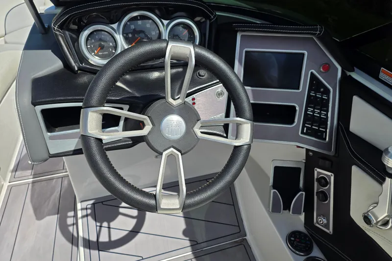 Slide: The Image of 2019 MasterCraft XT23 boat dashboard with steering wheel and control panel. - 13