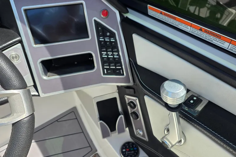 Slide: The Image of 2019 MasterCraft XT23 dashboard with steering wheel, control panel, and throttle lever. - 14