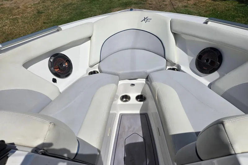 Slide: The Image of 2019 MasterCraft XT23 boat interior with white seating and built-in speakers. - 16