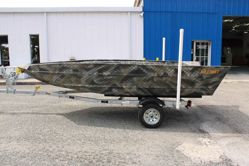 Slide: The Image of 2026 WeldBilt 1660V boat on trailer in front of blue building. - 3