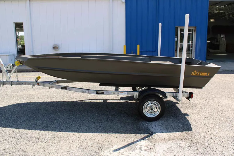 Slide: The Image of 2026 WeldBilt 1448V boat on trailer in front of blue building. - 6