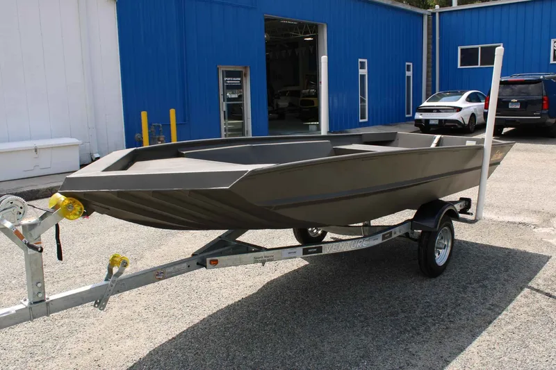 Slide: The Image of 2026 WeldBilt 1448V boat on trailer outside blue workshop. - 4