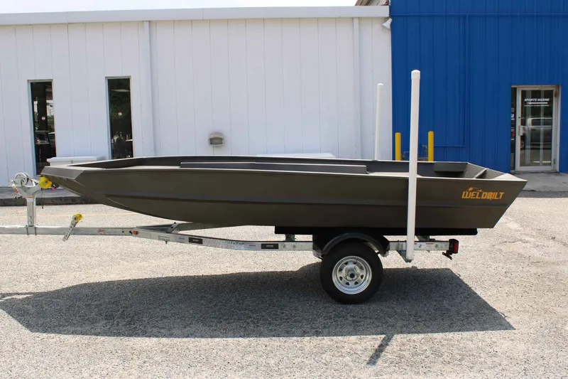 Slide: The Image of 2026 WeldBilt 1448V boat on trailer in front of building. - 5