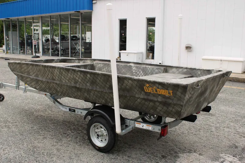 Slide: The Image of 2026 WeldBilt 1448V boat on trailer in front of a building. - 4