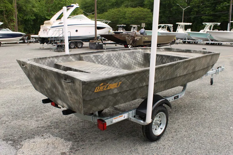 Slide: The Image of 2026 WeldBilt 1448V boat displayed on trailer outdoors. - 6
