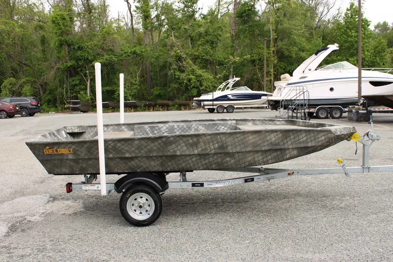 Slide: The Image of 2026 WeldBilt 1448V boat on trailer parked outdoors. - 7