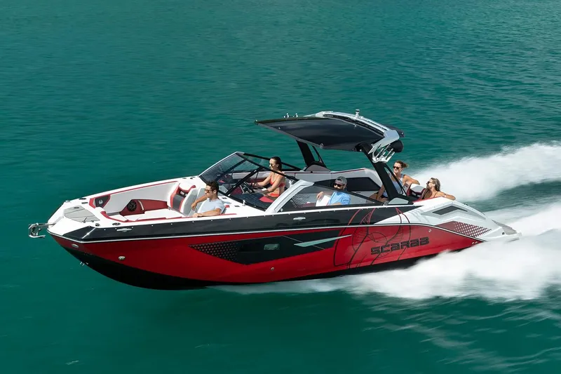Slide: The Image of 2021 Scarab 285 ID boat on blue water, multiple people onboard. - 2