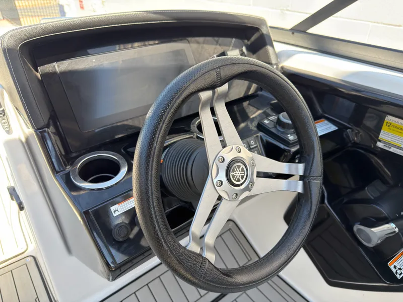 Slide: The Image of Steering wheel and dashboard of a 2020 Yamaha 242S boat. - 34