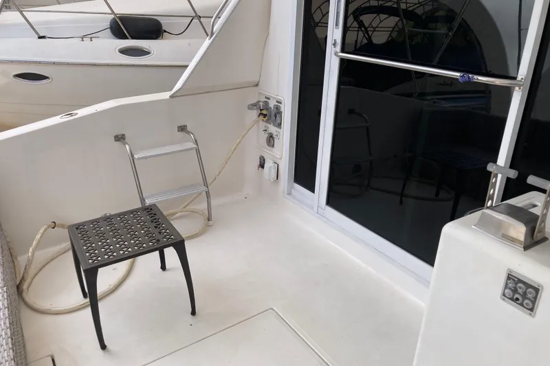 Slide: The Image of 1995 Sea Ray 550 Sedan Bridge yacht deck with ladder and stool. - 10