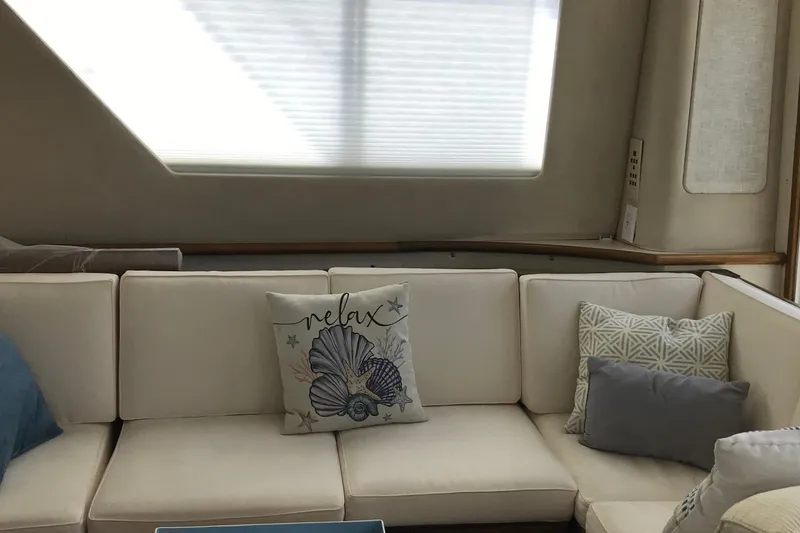 Slide: The Image of Interior of 1995 Sea Ray 550 Sedan Bridge with cozy white seating and decorative pillows. - 12