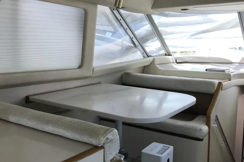 Slide: The Image of Interior of 1995 Sea Ray 550 Sedan Bridge yacht with dining area and windows. - 16