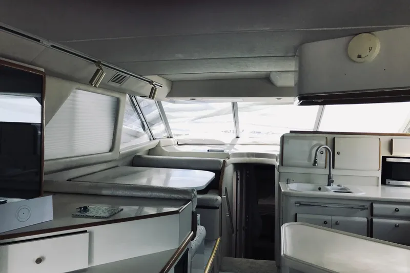 Slide: The Image of Interior of a 1995 Sea Ray 550 Sedan Bridge yacht, featuring a modern kitchen and seating area. - 17