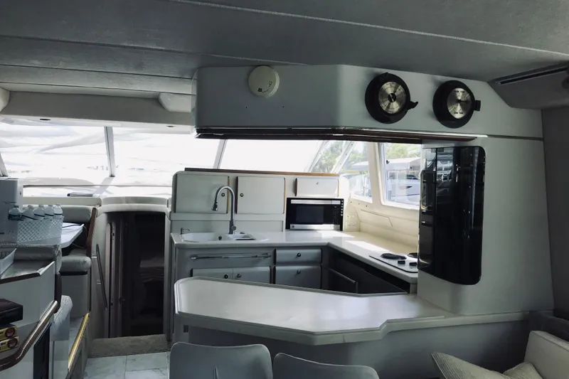 Slide: The Image of Interior of a 1995 Sea Ray 550 Sedan Bridge yacht, featuring a modern kitchen area. - 18