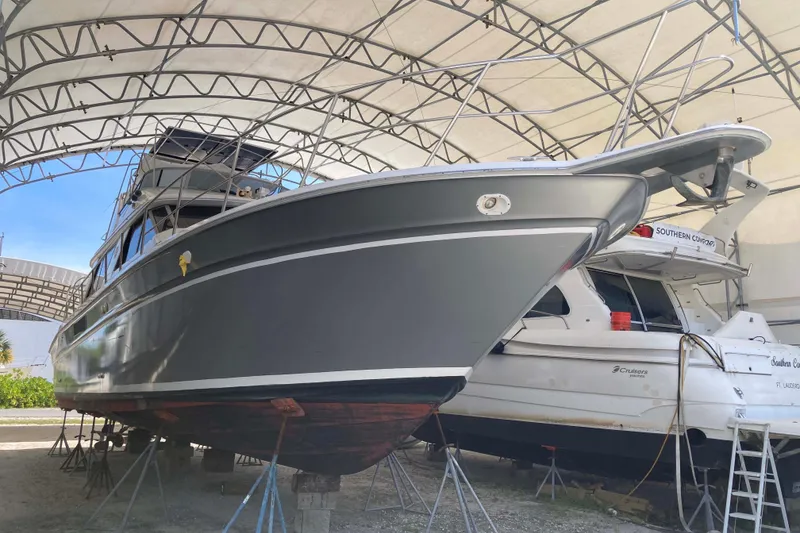 Slide: The Image of 1995 Sea Ray 550 Sedan Bridge yacht under a protective canopy in a boatyard. - 2