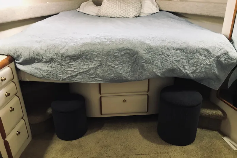 Slide: The Image of Cozy bedroom interior of 1995 Sea Ray 550 Sedan Bridge with blue bedding and storage drawers. - 21