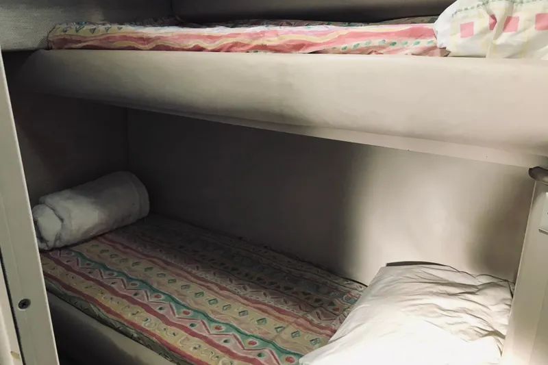 Slide: The Image of Bunk beds in 1995 Sea Ray 550 Sedan Bridge yacht cabin, featuring colorful bedding. - 25