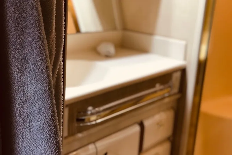 Slide: The Image of Bathroom interior of 1995 Sea Ray 550 Sedan Bridge yacht, featuring a towel and sink. - 27