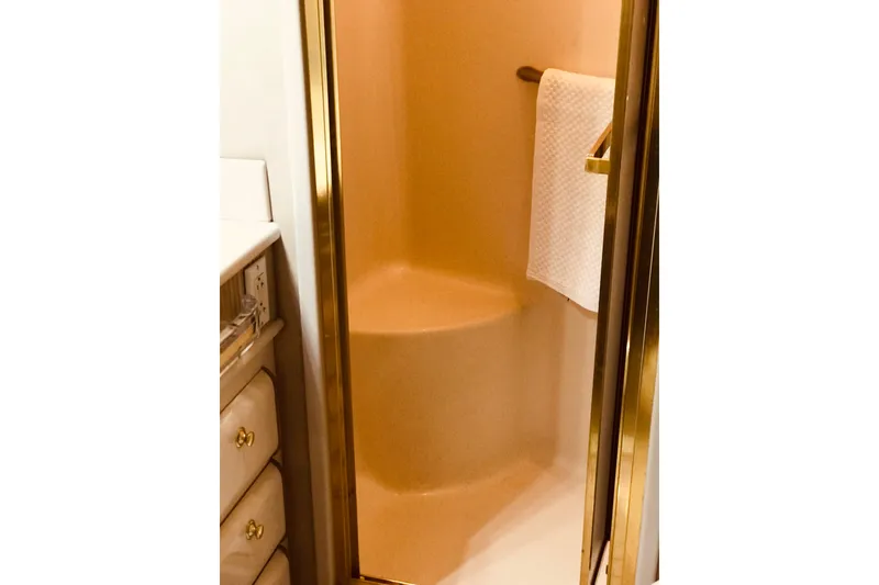 Slide: The Image of Shower area in 1995 Sea Ray 550 Sedan Bridge yacht with gold accents and towel rack. - 29