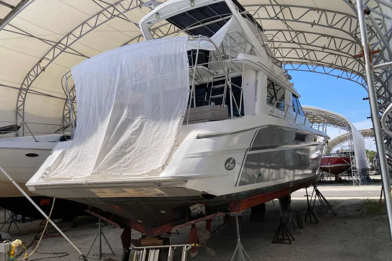 Slide: The Image of 1995 Sea Ray 550 Sedan Bridge yacht under maintenance in a covered boatyard. - 3