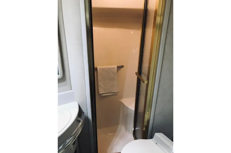 Slide: The Image of Bathroom interior of 1995 Sea Ray 550 Sedan Bridge yacht, featuring shower and towel. - 31