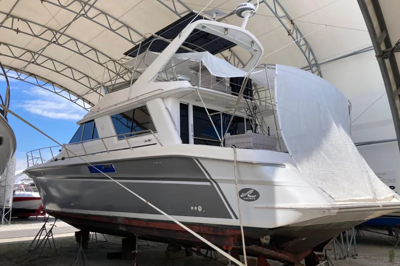 Slide: The Image of 1995 Sea Ray 550 Sedan Bridge yacht under a protective canopy in a boatyard. - 4