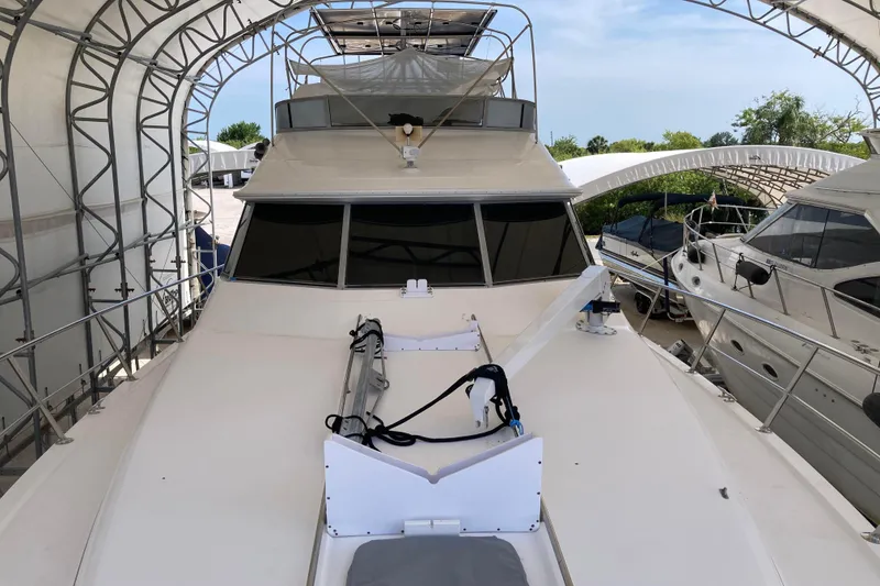Slide: The Image of 1995 Sea Ray 550 Sedan Bridge yacht docked under a canopy. - 5