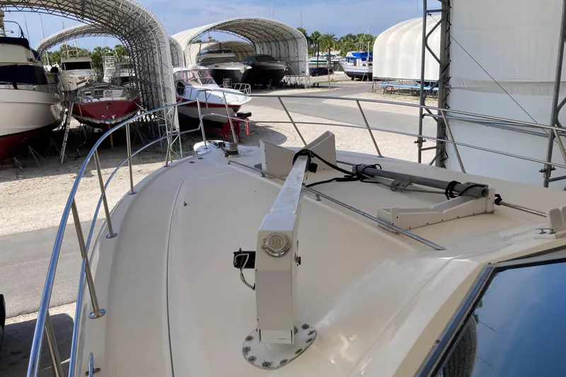 Slide: The Image of 1995 Sea Ray 550 Sedan Bridge yacht in marina storage, surrounded by other boats. - 6