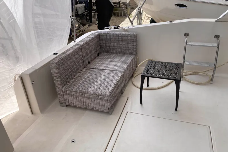 Slide: The Image of 1995 Sea Ray 550 Sedan Bridge deck with wicker seating and small table. - 8