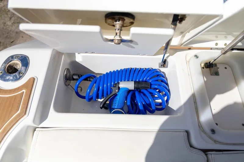 Slide: The Image of Storage compartment with blue hose on 2006 Hydra-Sports Vector 3300 VX boat. - 21