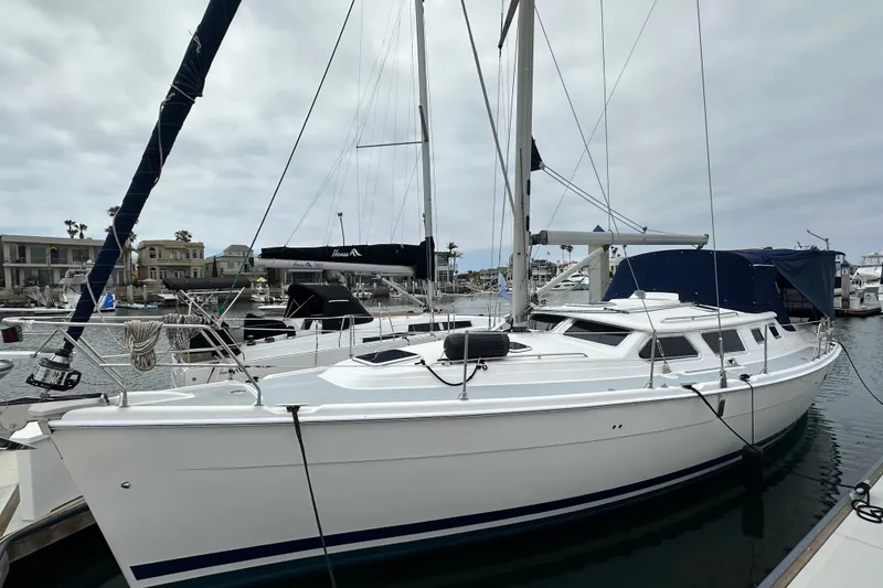 The Image of 2003 Hunter 426 Deck Salon sailboat docked in a marina, showcasing sleek design and spacious deck. - 1
